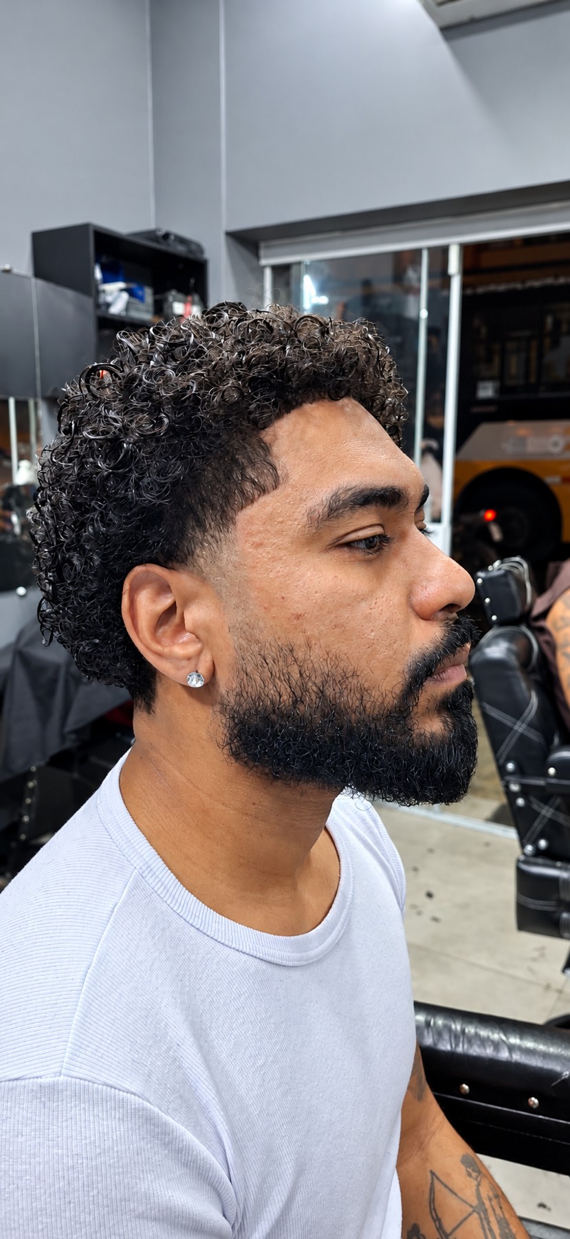 Corte cacheado com laterais baixas e barba alinhada — Los Bárbaros